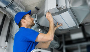 image of a hvac technician working to install a ventilation system