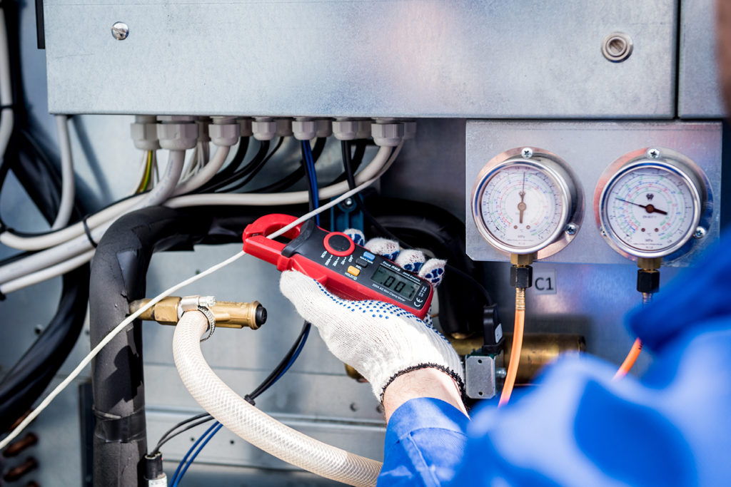 image of a heating and air technician checking power to the heating unit